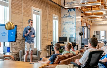 Man-explaining-personal-branding-strategy-to-his-coworkers